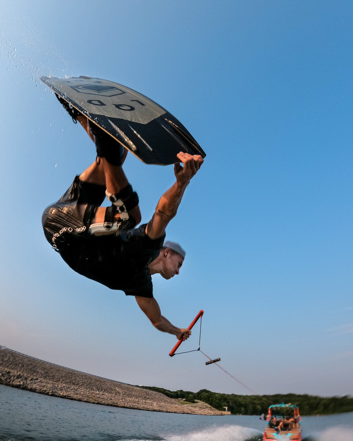 Runner's Athletics community wakeboarder flipping above the lake