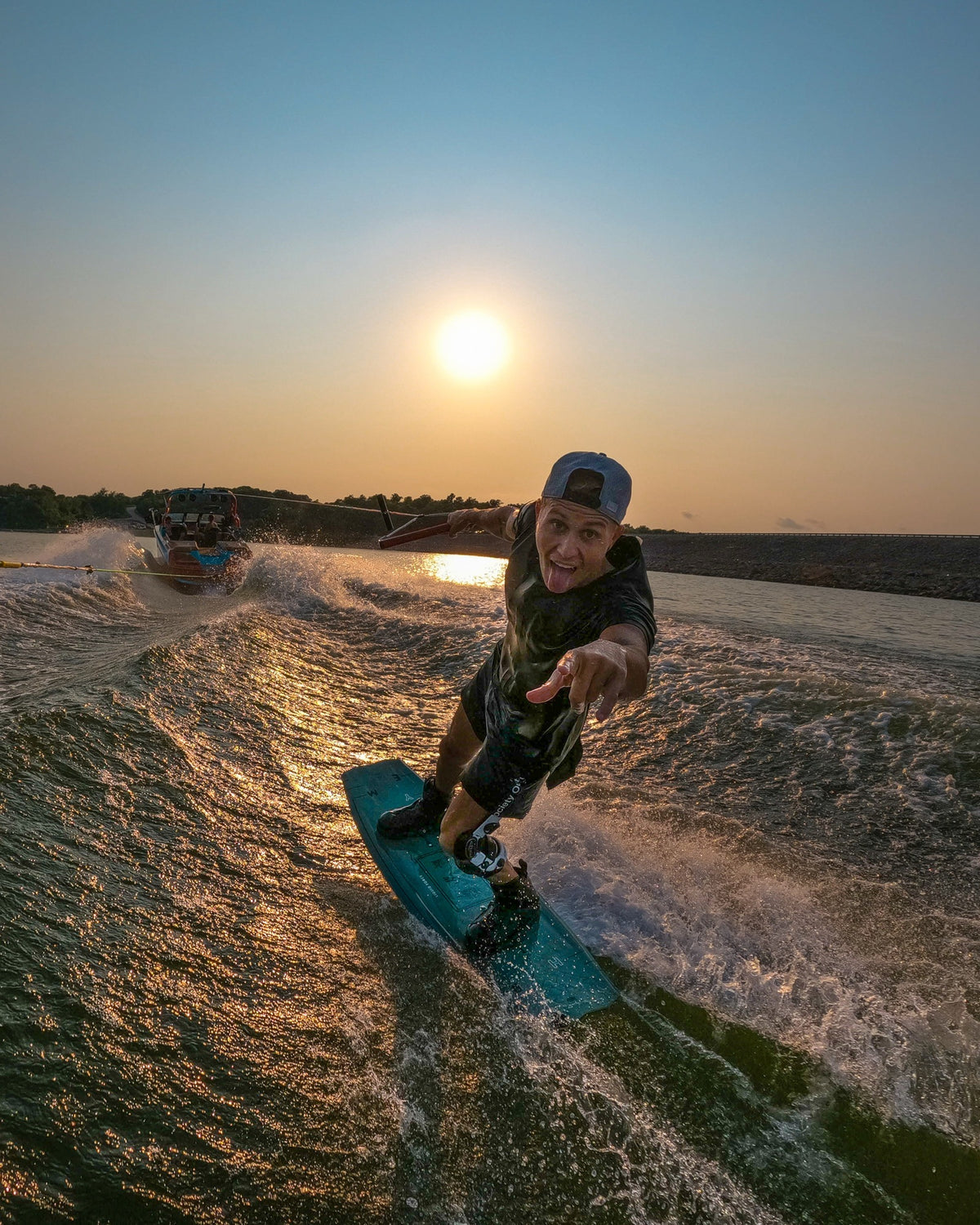 Runner's Athletics community wakeboarder carving the lake at sunset