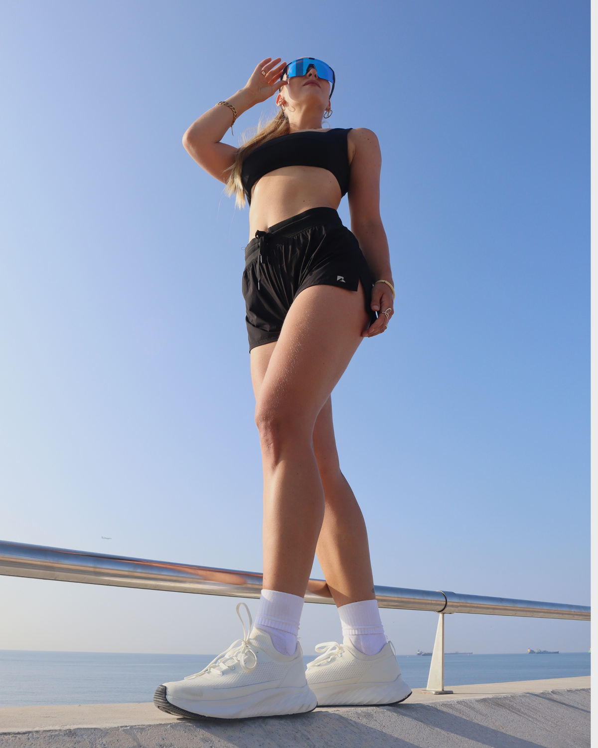 Person in athletic sports wear standing on a road with a clear blue sky