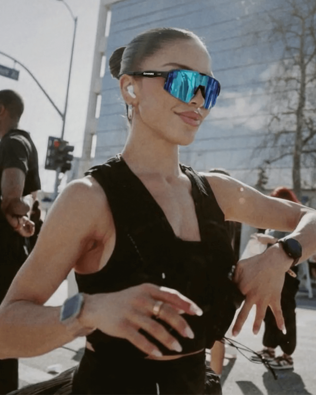 Woman wearing polarized x365 sunglasses and a black sleeveless top outdoors.