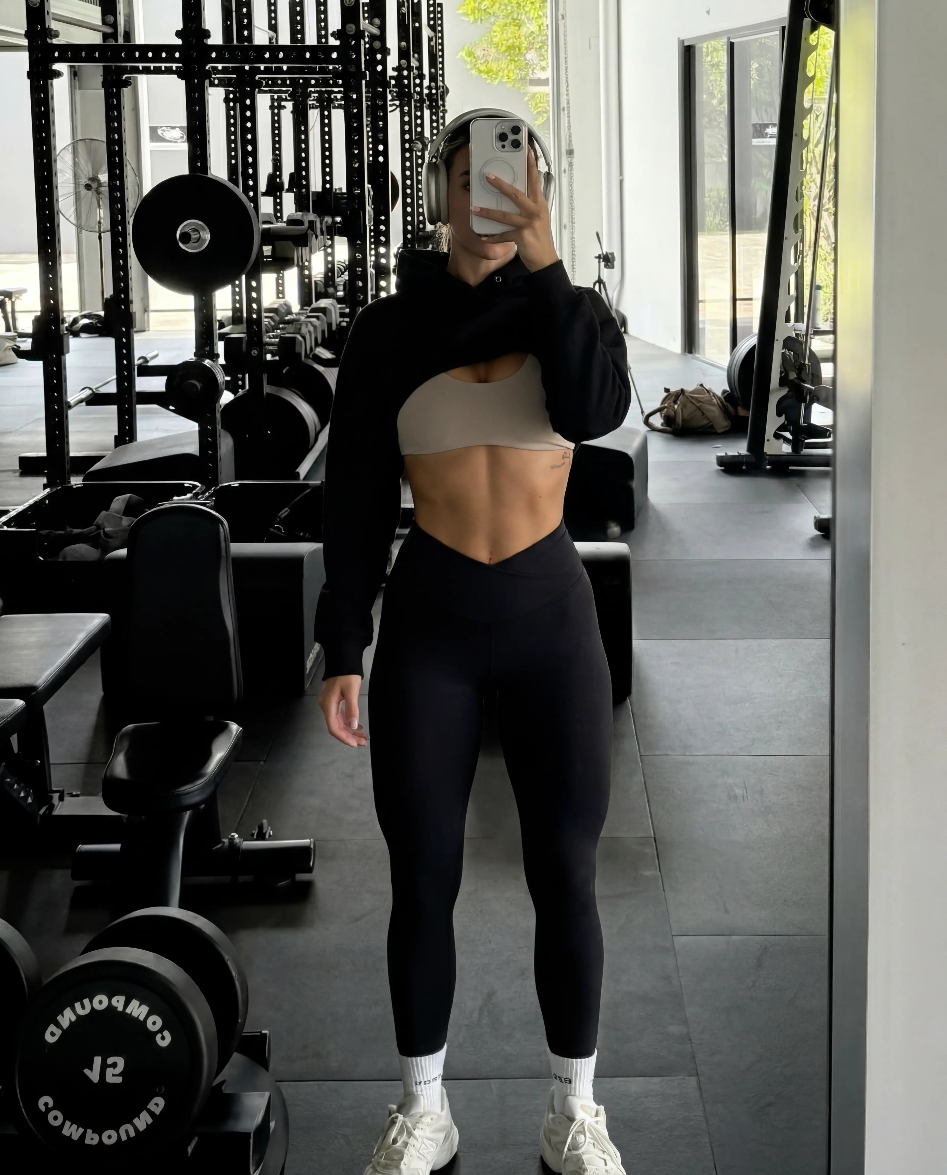 Black cropped hoodie with tan sports bra and high waist leggings gym selfie