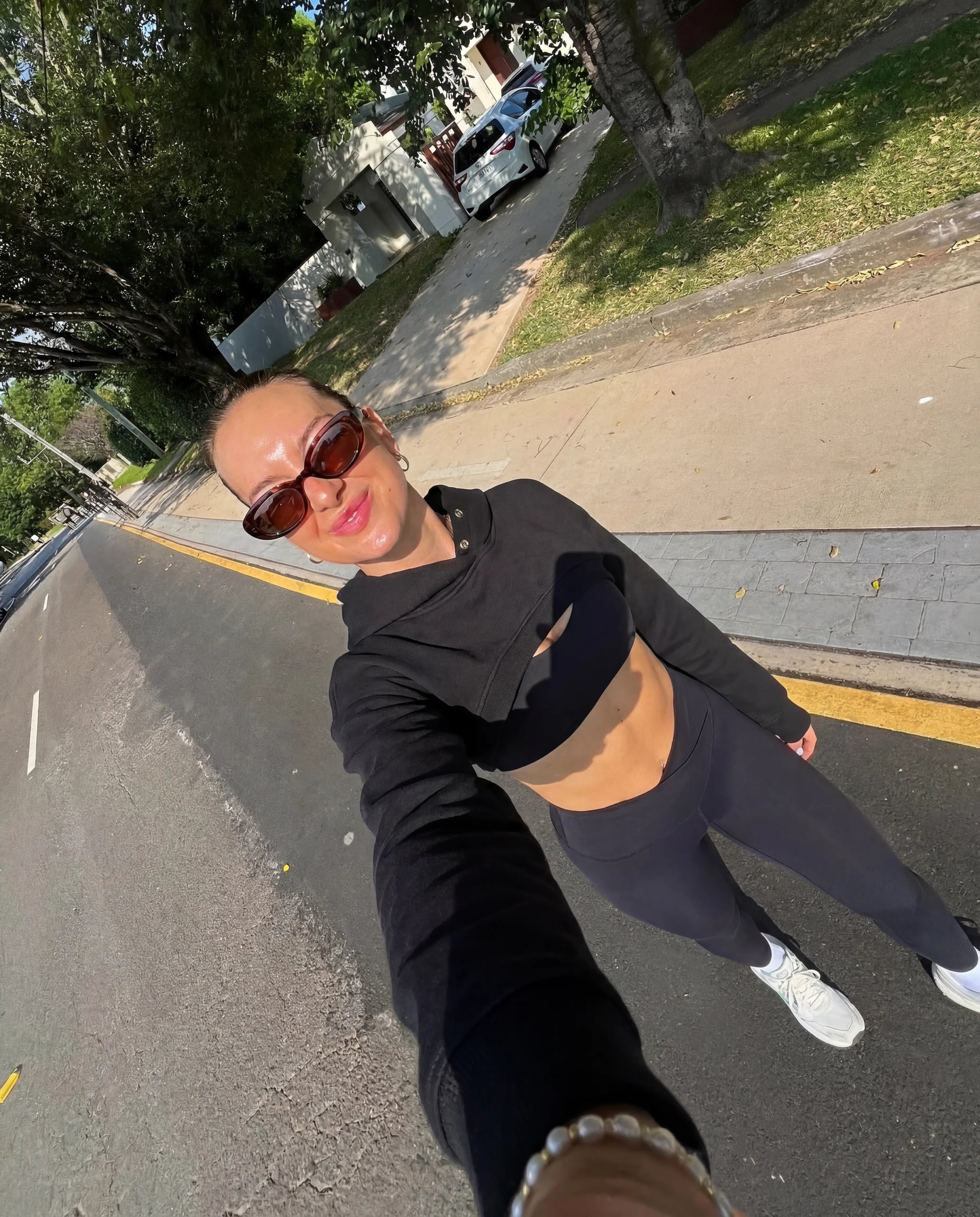 Black cropped hoodie and leggings worn on sunny morning street walk