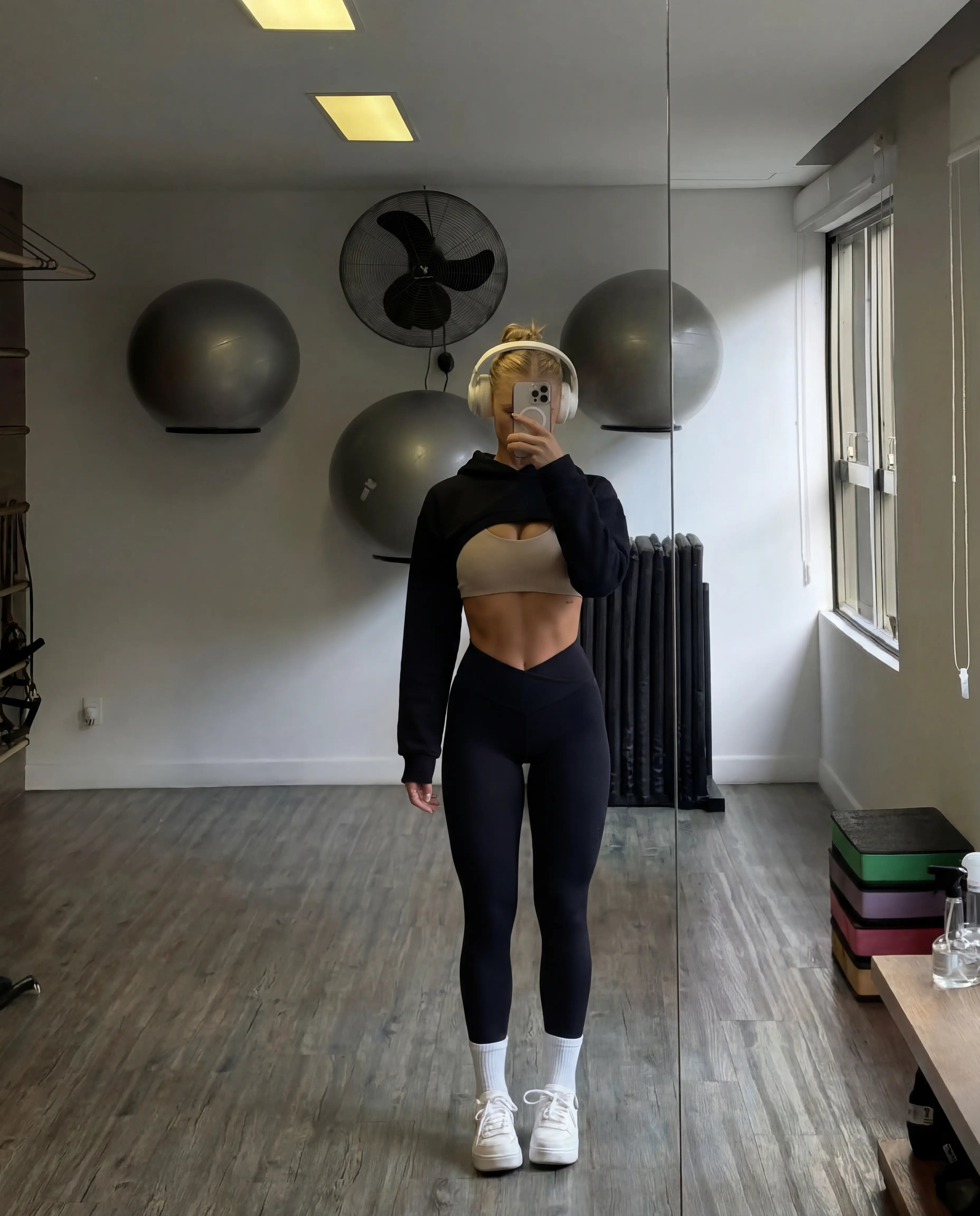 Black cropped hoodie and high waist leggings full body pilates studio