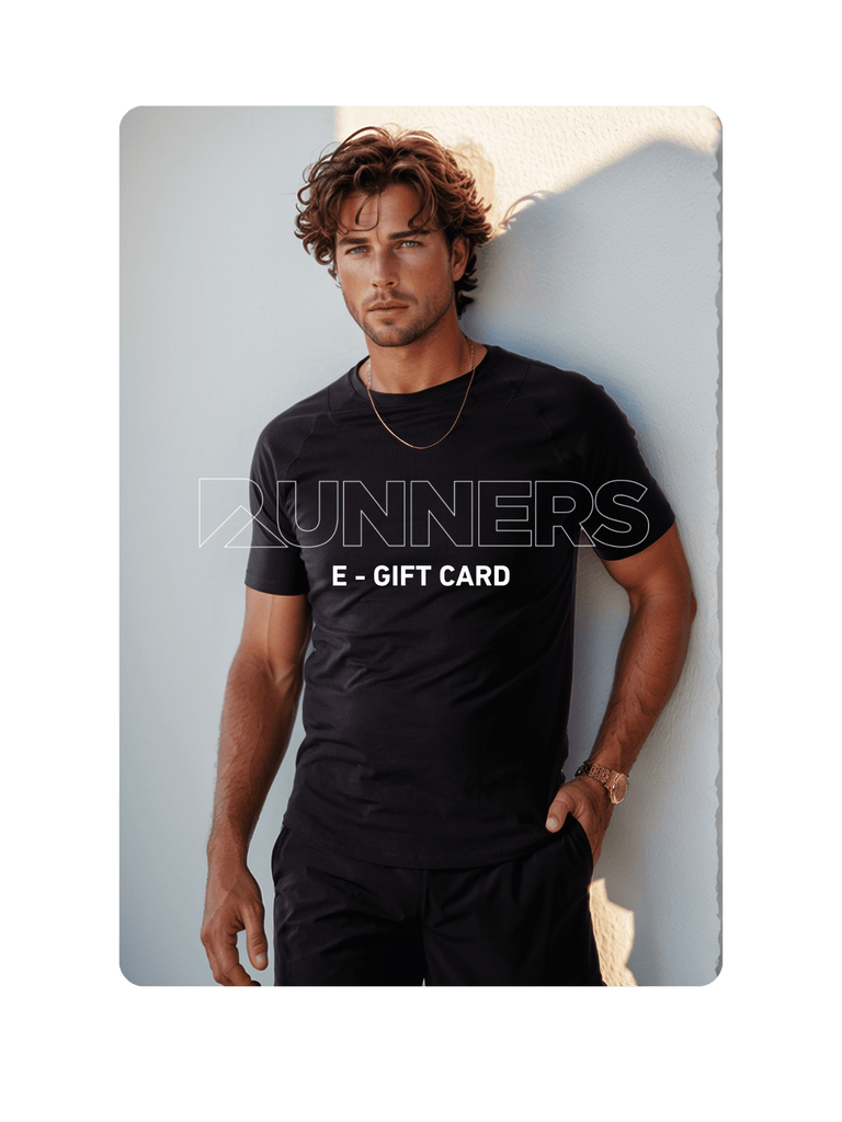 Woman in sunglasses, white crop top, and shorts. Gold jewelry. White background.