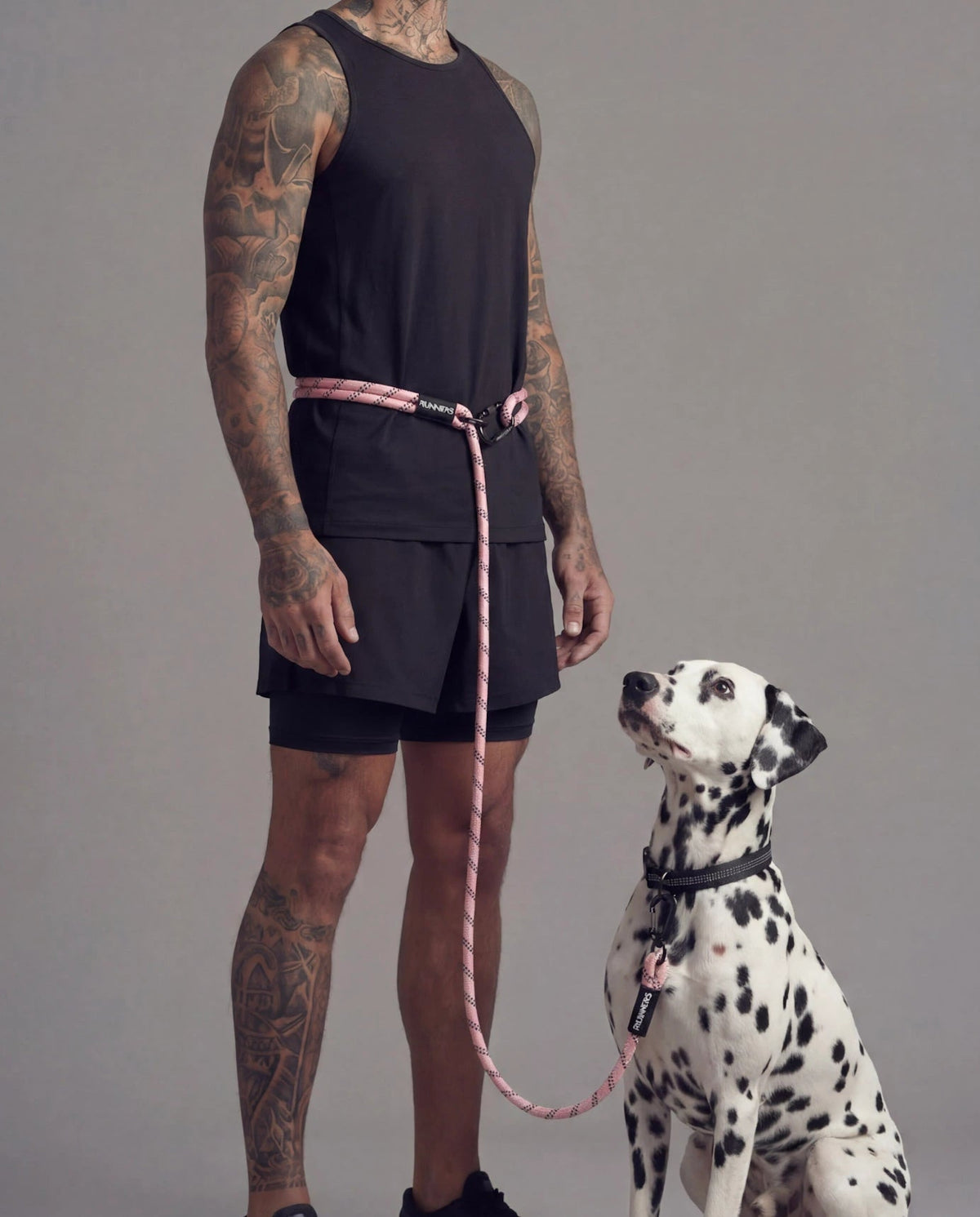 Pink hands free dog leash worn around waist with Dalmatian dog