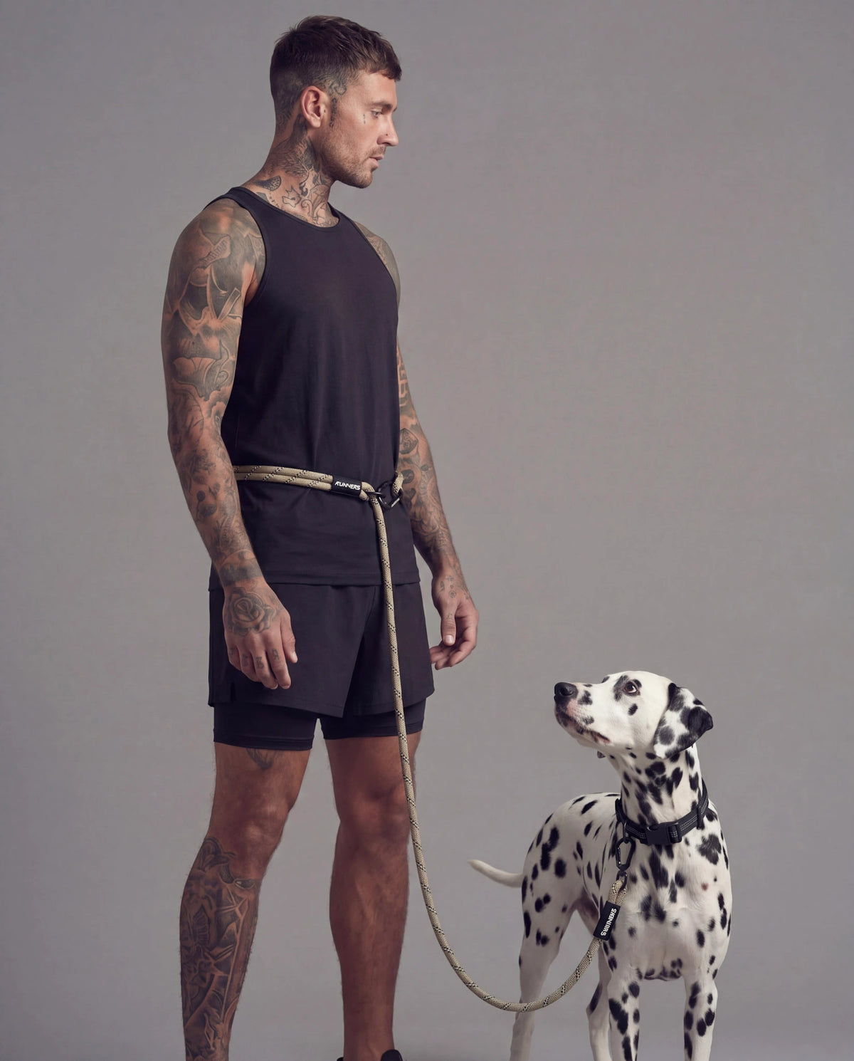 Olive hands free dog leash worn around waist with Dalmatian dog