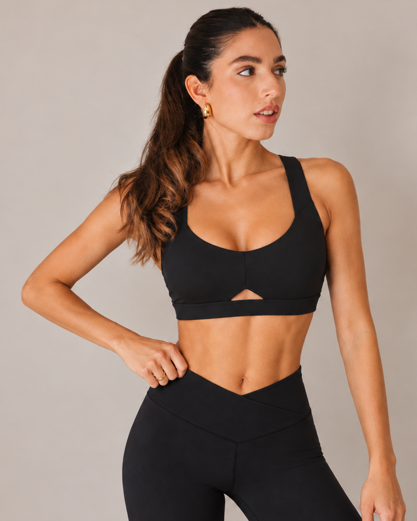 Woman in the black Heart Neckline Sports Bra and high-waist leggings, three-quarter view