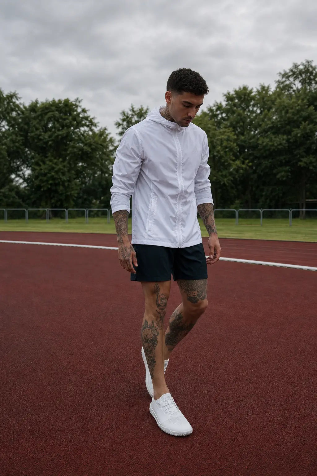 White mens barefoot trainer minimalist shoe on model wearing white windbreaker on running track