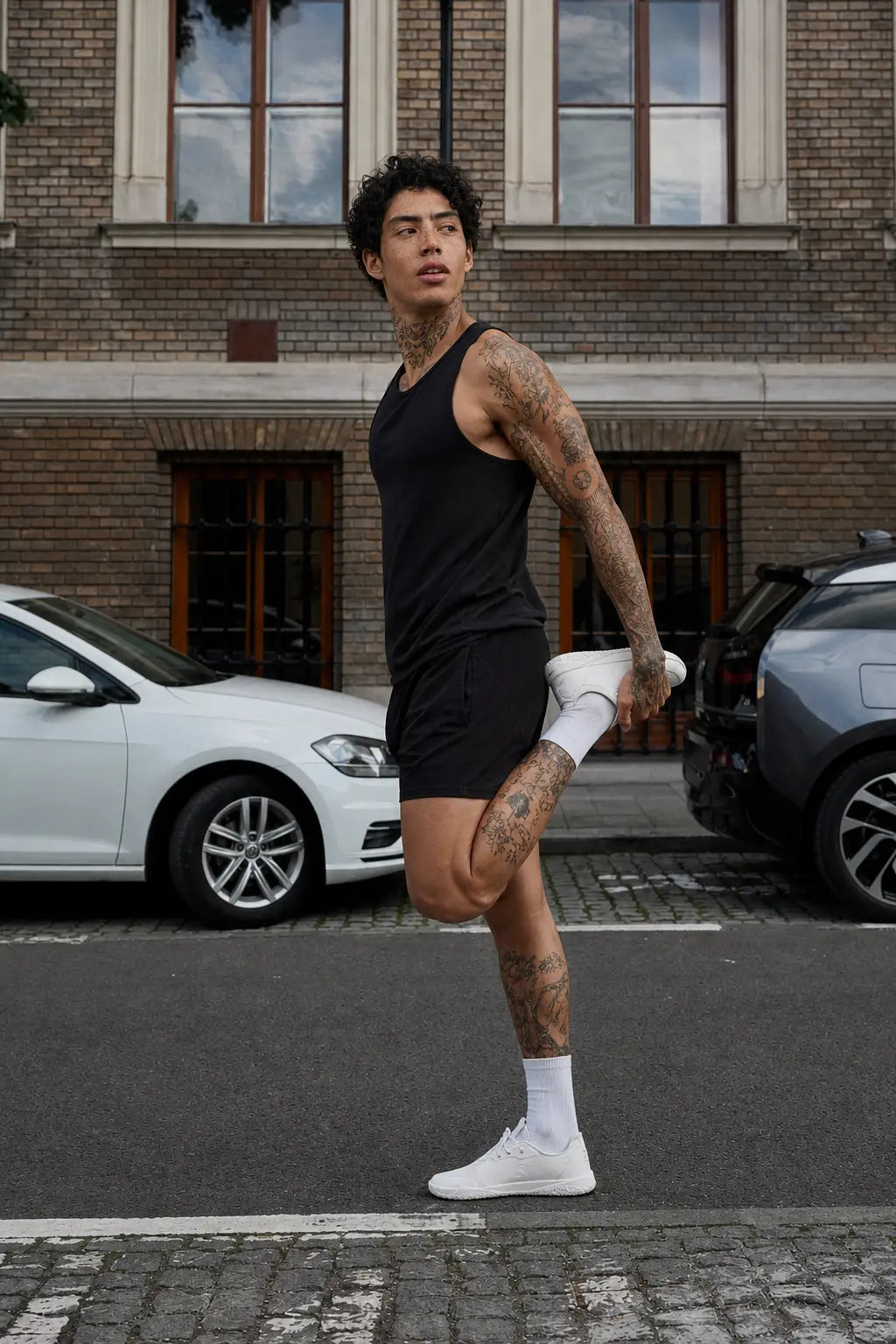 White mens barefoot trainer minimalist shoe on model stretching outdoors on city street