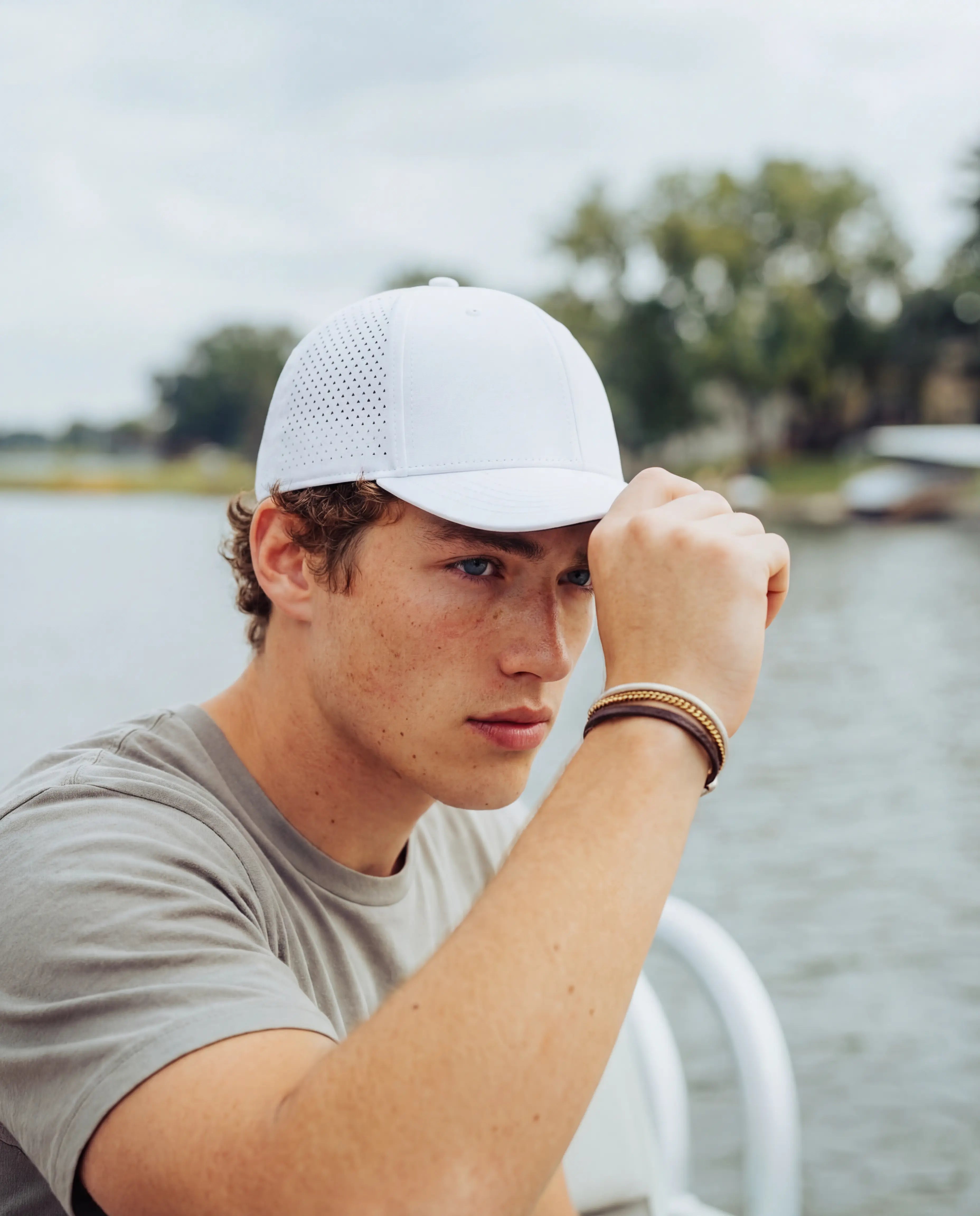 White perforated running hat with structured brim on man in grey athletic tee from Runners Athletics