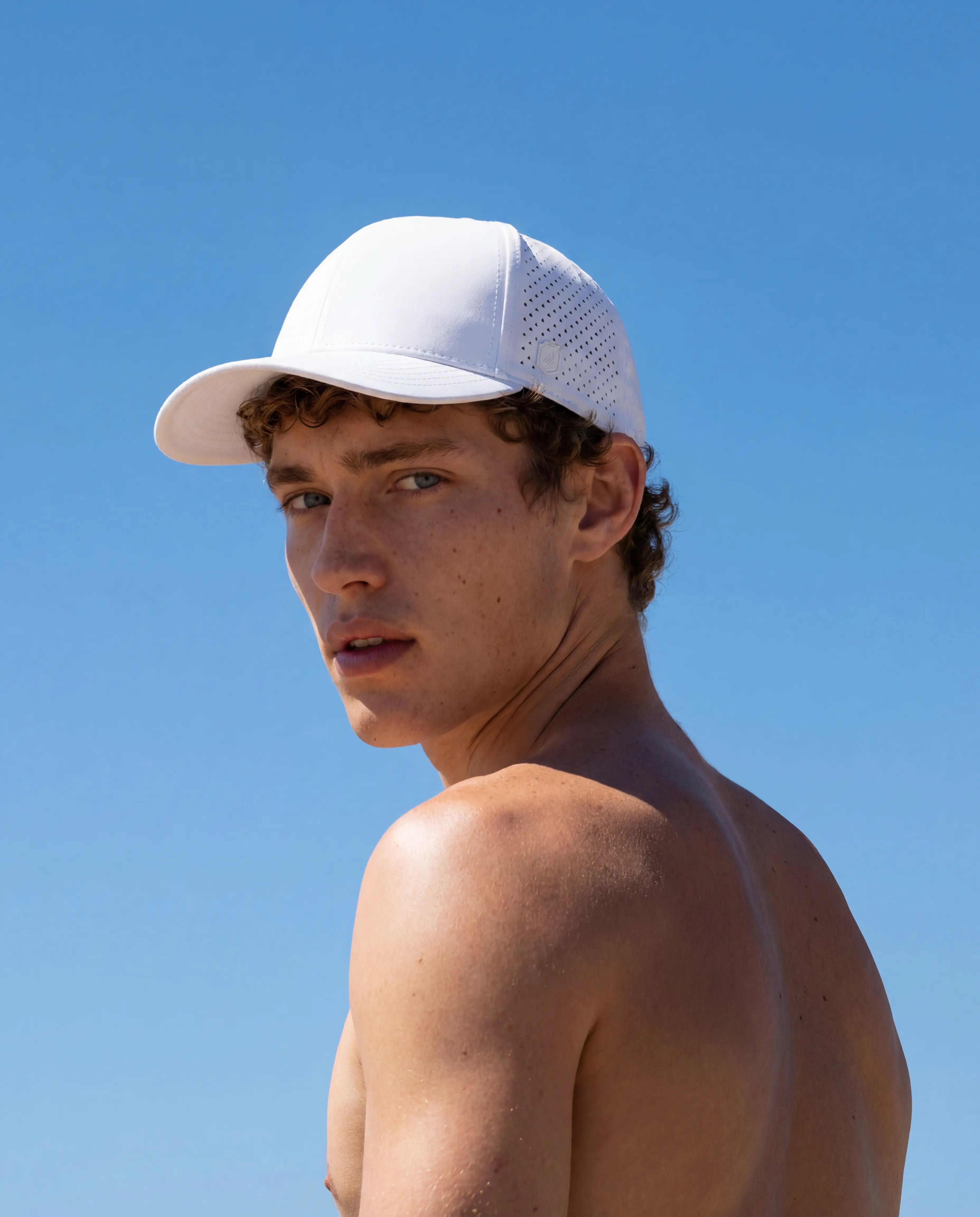 White perforated lightweight running hat with ventilation panels worn outdoors from Runners Athletics