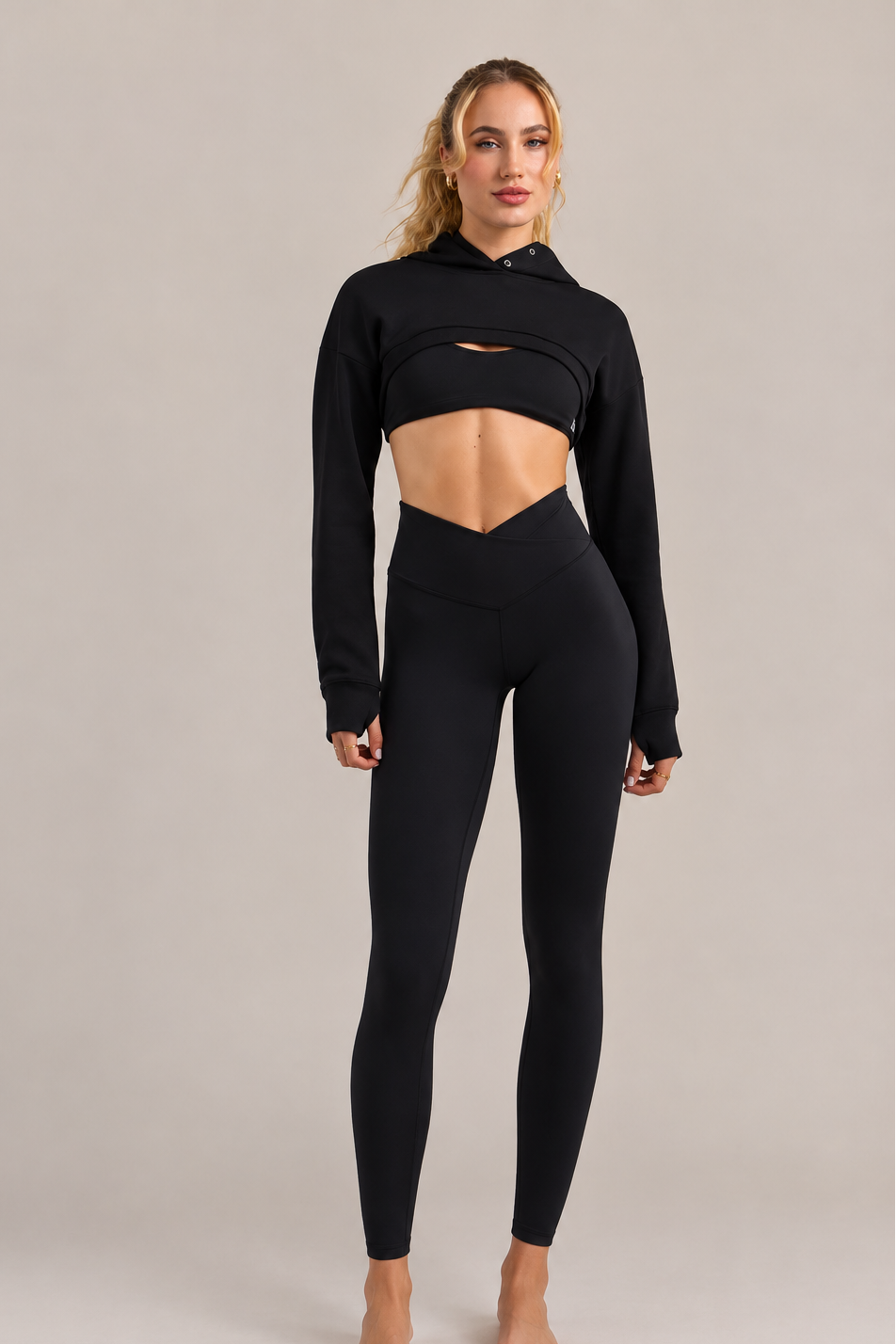 Woman wearing The Naked Leggings, black high-waisted leggings, with a black cropped hoodie, full-length front view