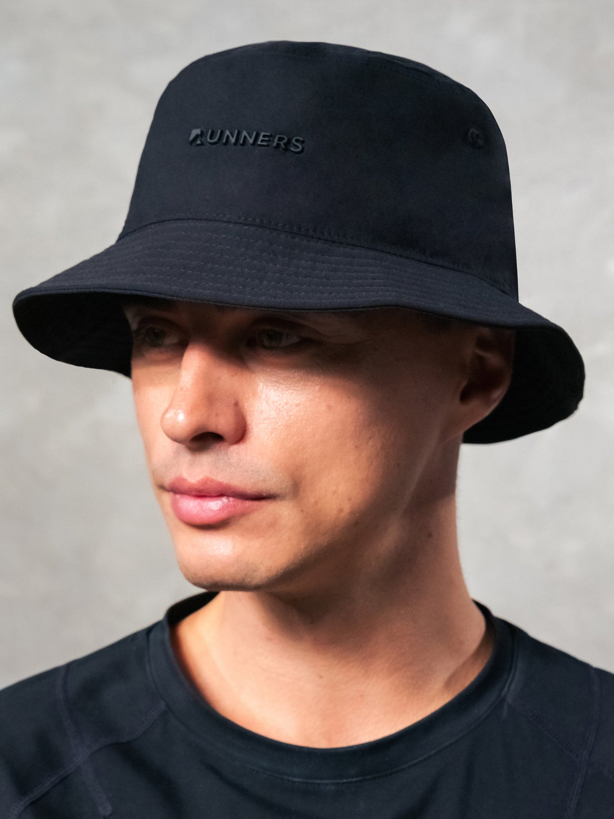 Close up detail of quick-dry fabric on black performance bucket hat for runners