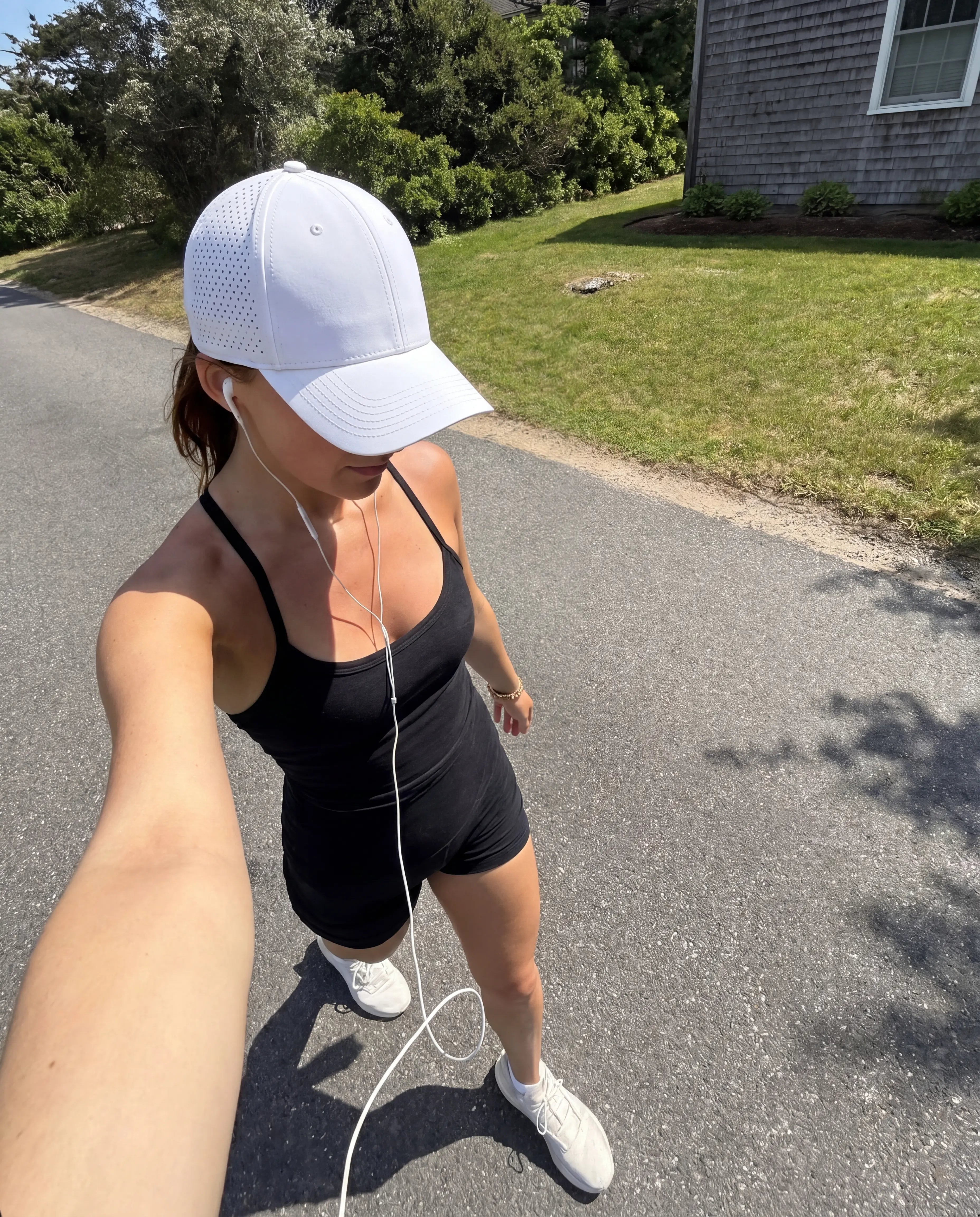 White perforated running hat and black workout set outdoor road walk