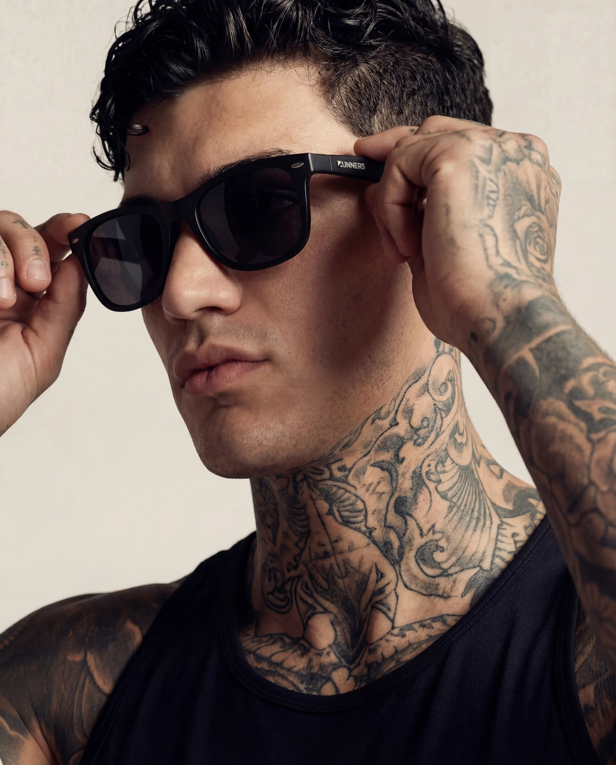 Black running sunglasses on tattooed male model close-up lifestyle shot