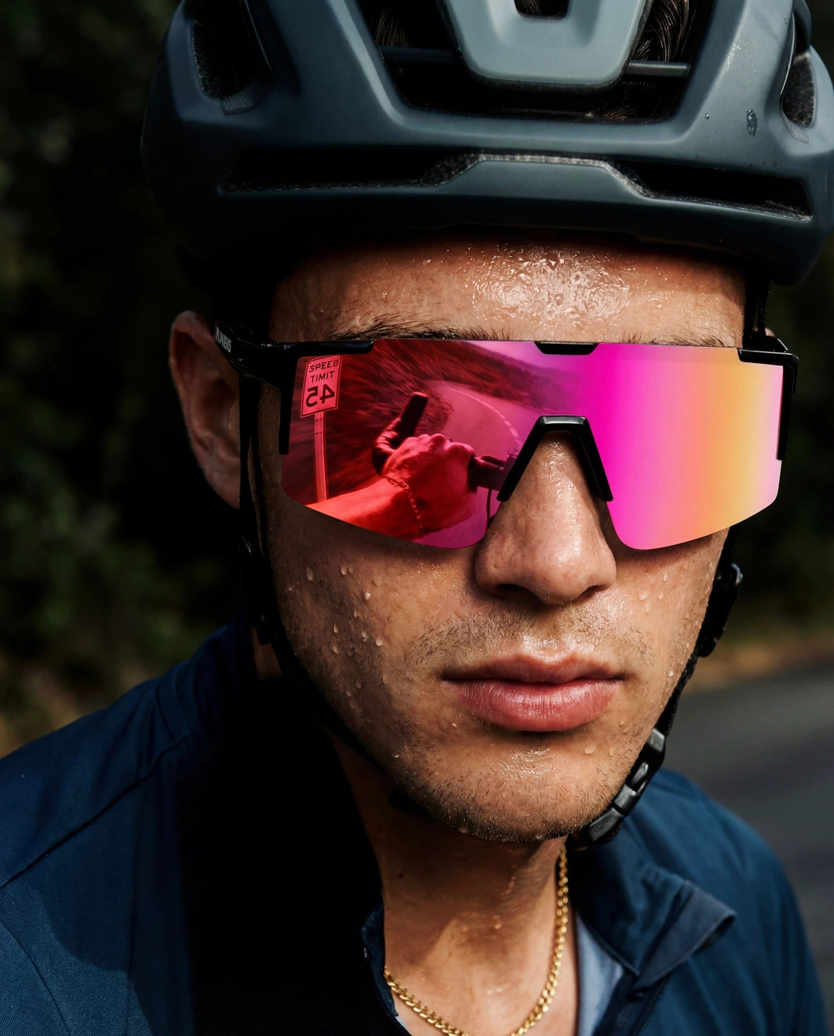 Close-up of man wearing cherry pink running sunglasses with cycling helmet
