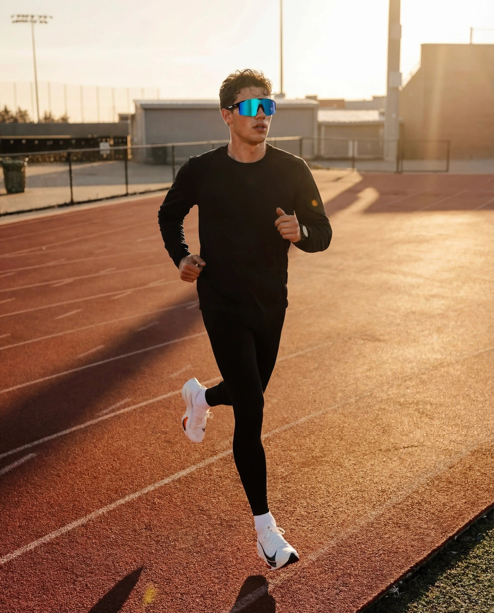Man running on athletics track wearing ice blue polarized running sunglasses 