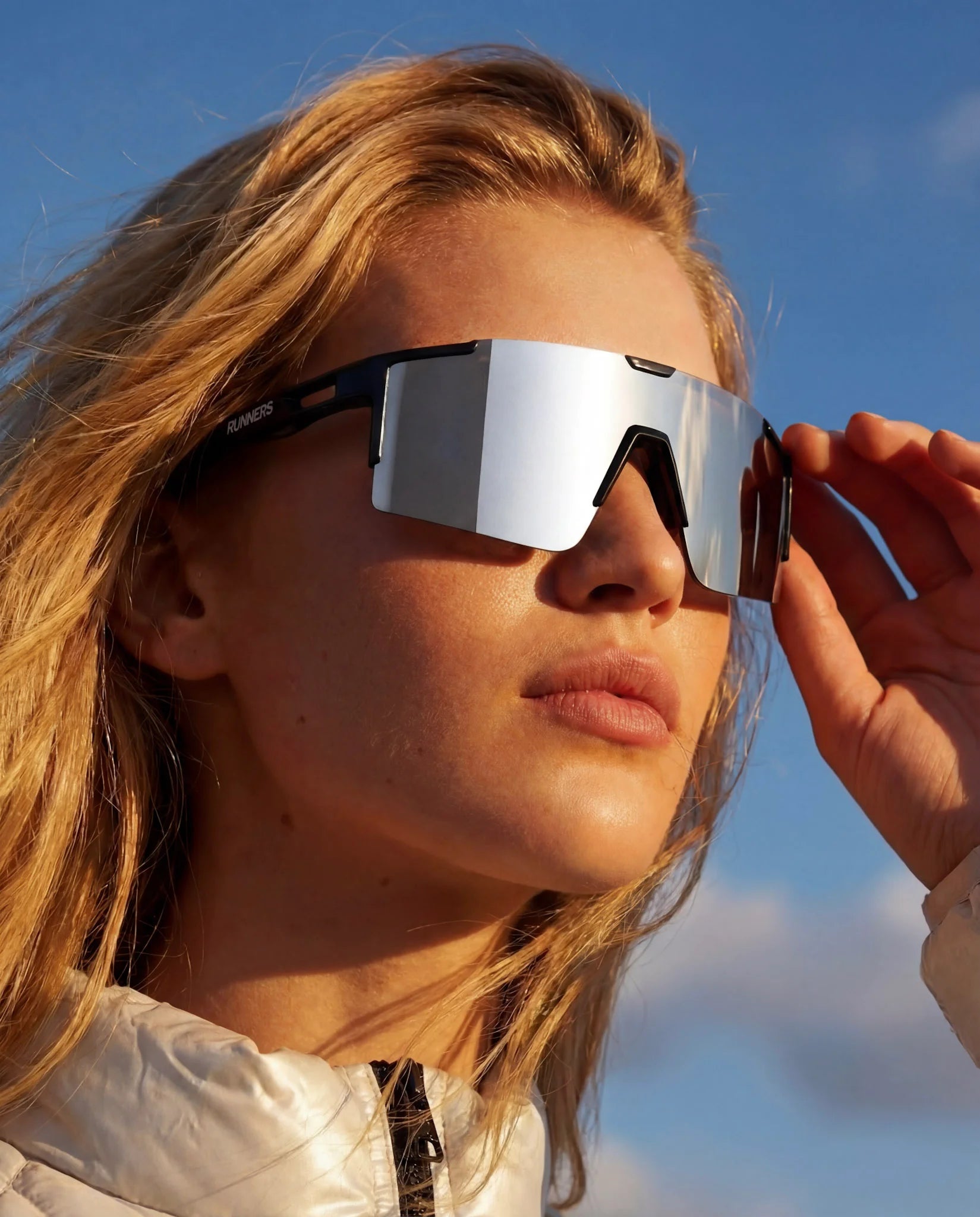 Woman adjusting revo silver running sunglasses outdoors 