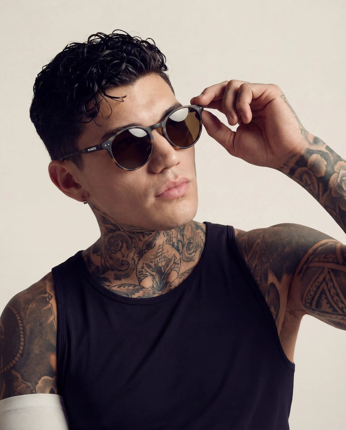 Round running sunglasses dark grey frame brown lenses on tattooed male model