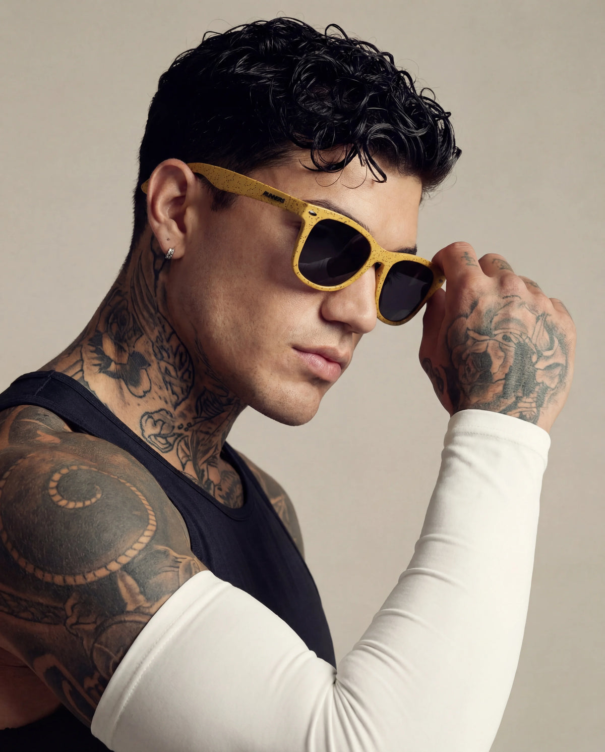 Yellow speckle running sunglasses on tattooed male model side view