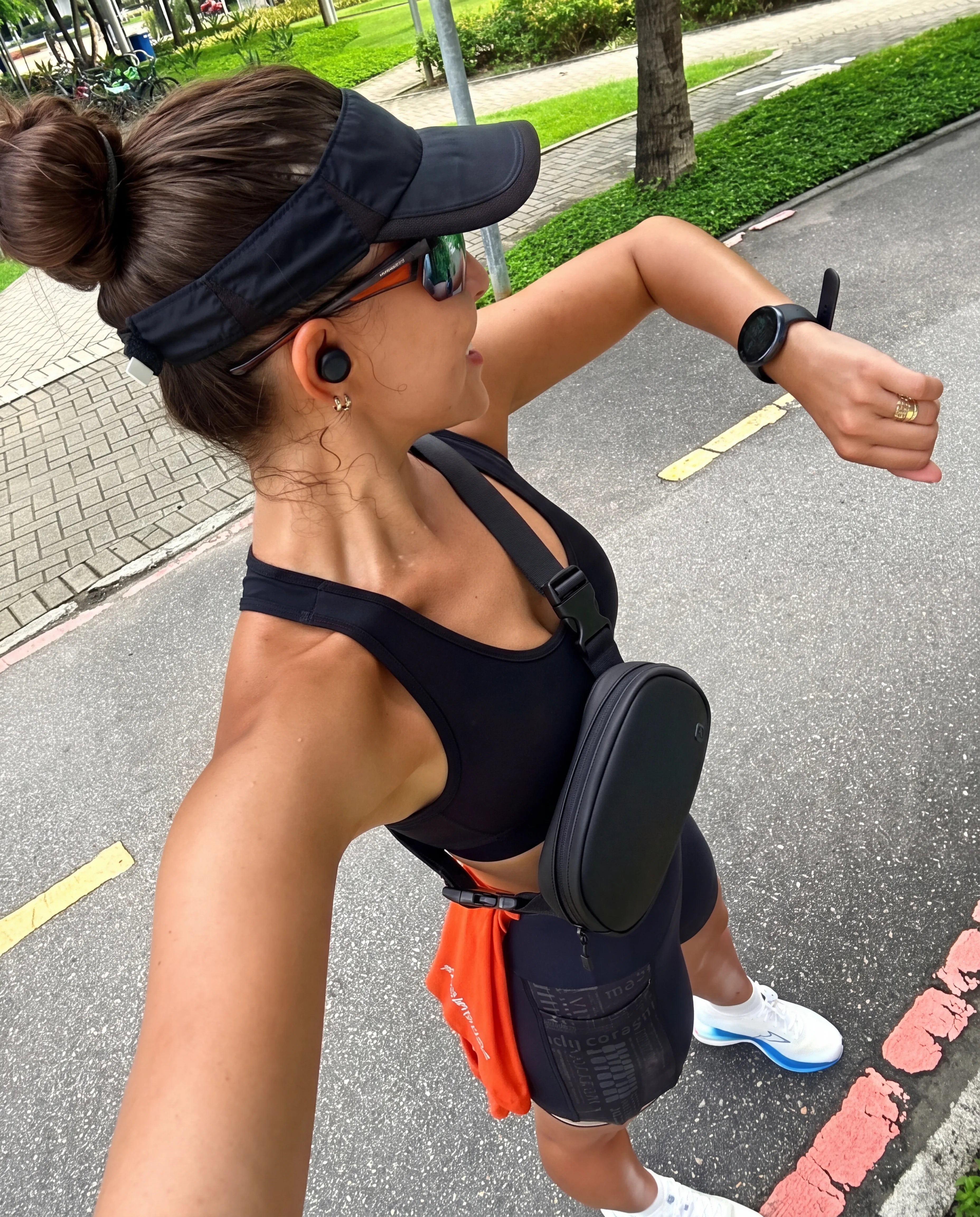 Black crossbody sling bag back view worn during outdoor street run