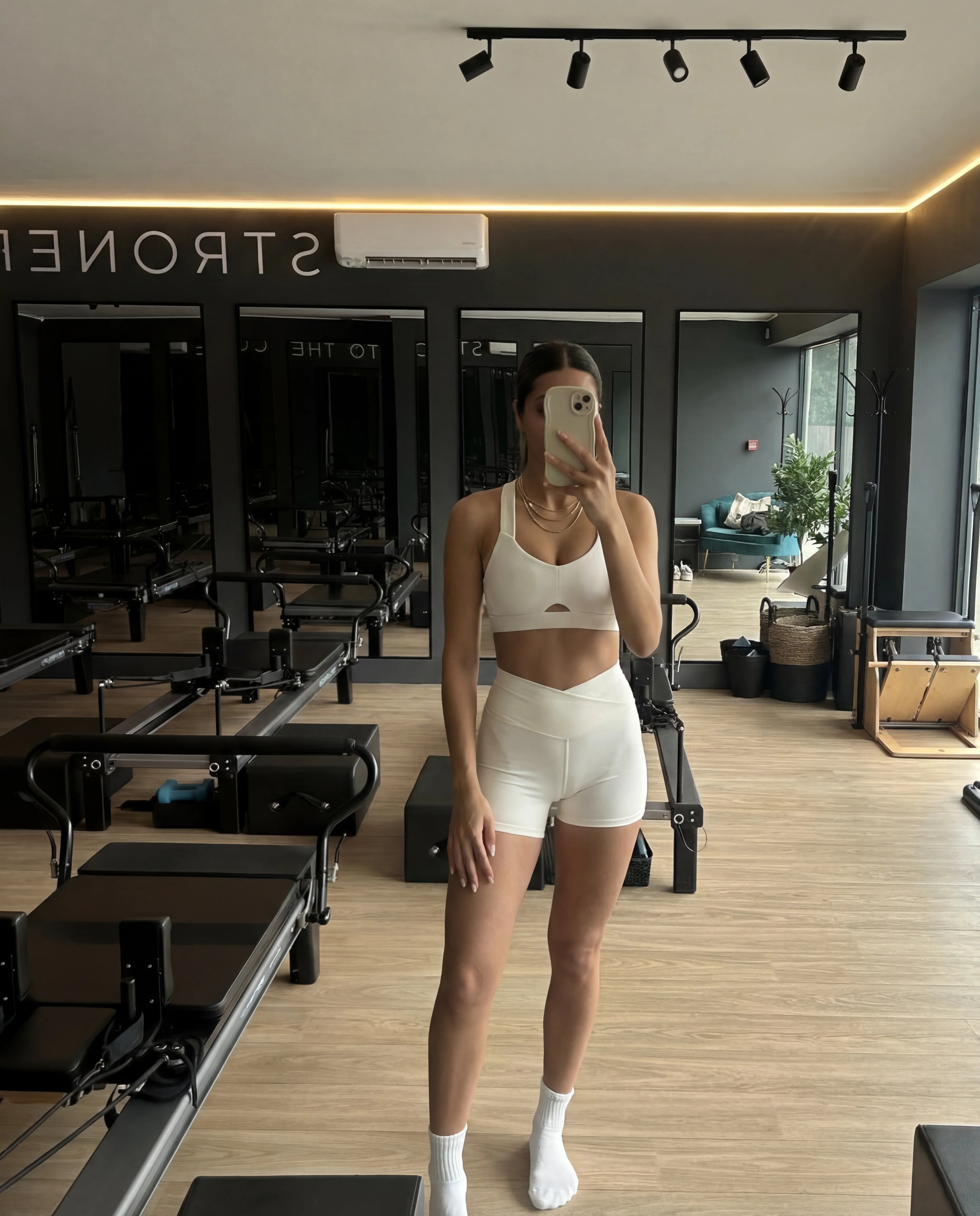 Beige workout set heart bra and sculpting shorts worn at pilates studio mirror selfie