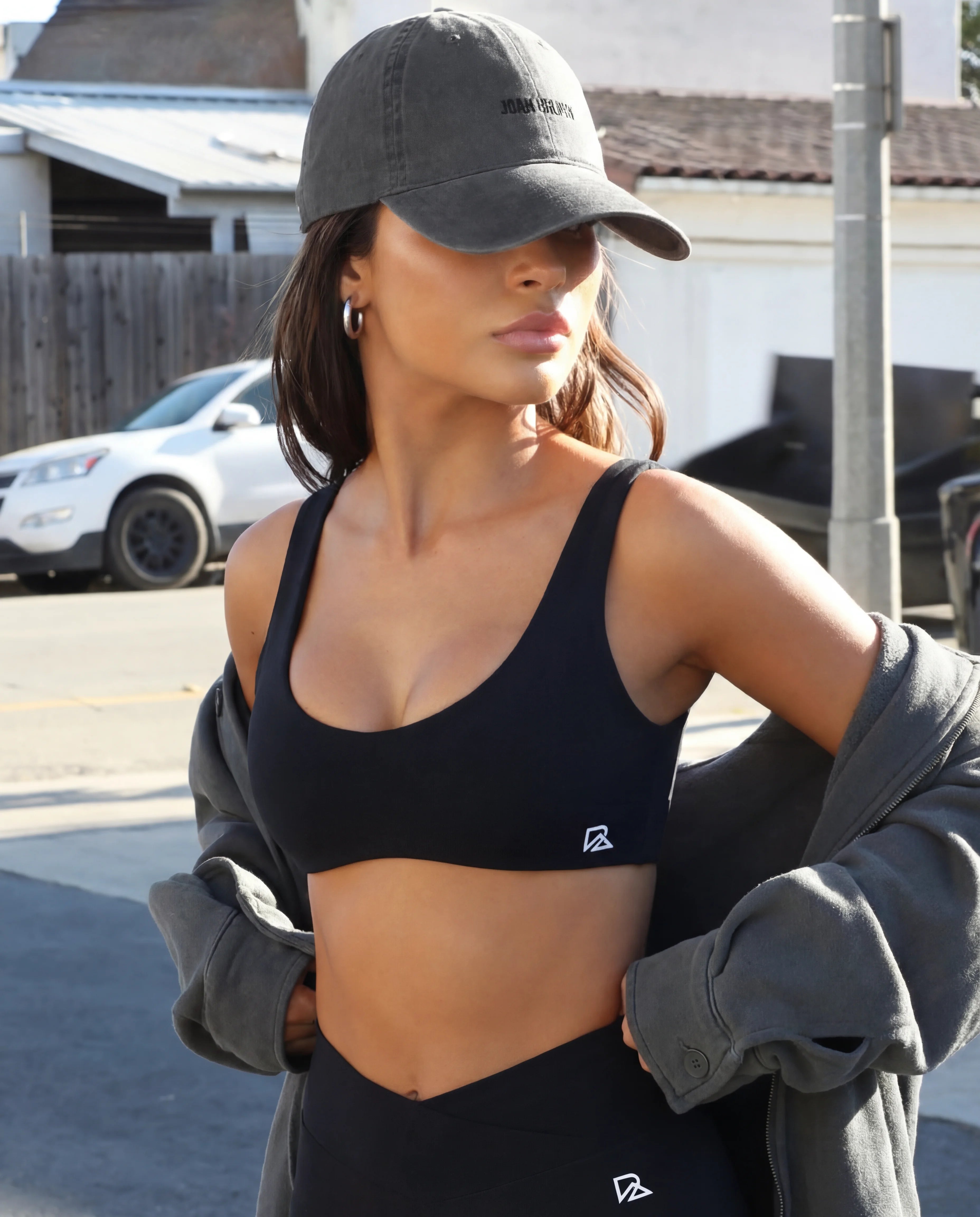 Black workout set sports bra and mini sculpting shorts worn on street with oversized jacket