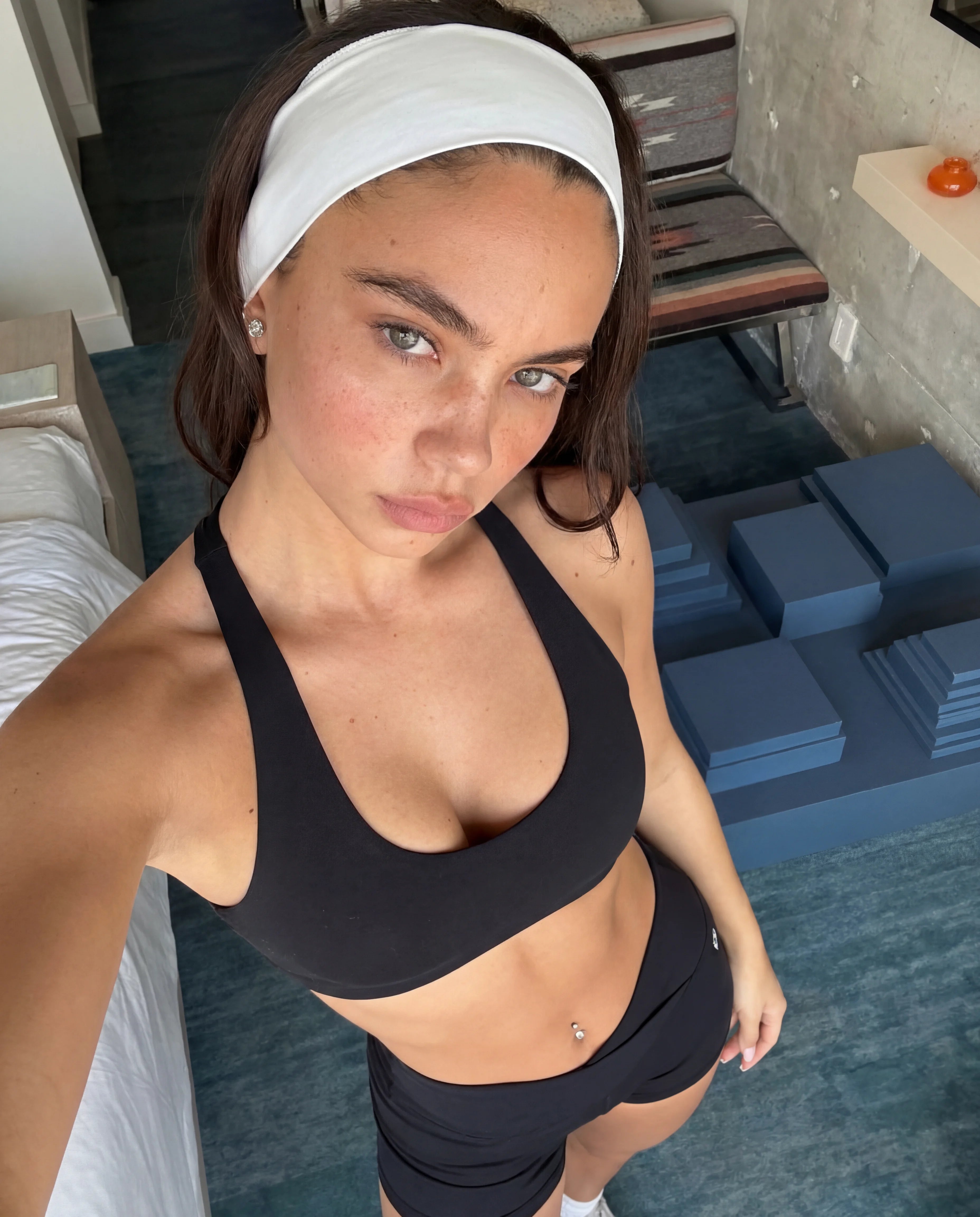 Black workout set strappy bra and mini sculpting shorts hotel room selfie